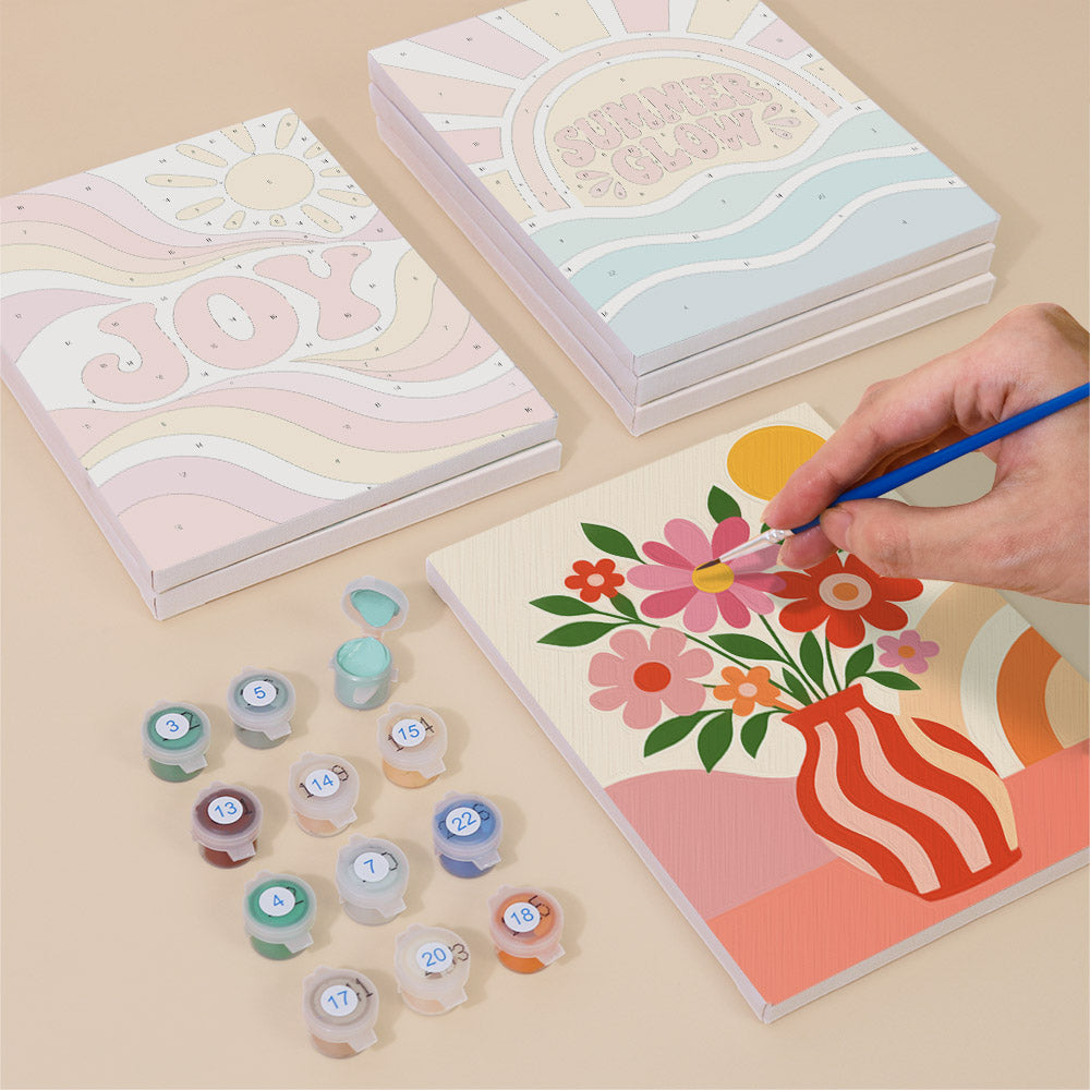 Painting one of the Summer Glow designs next to a stack of mini canvases