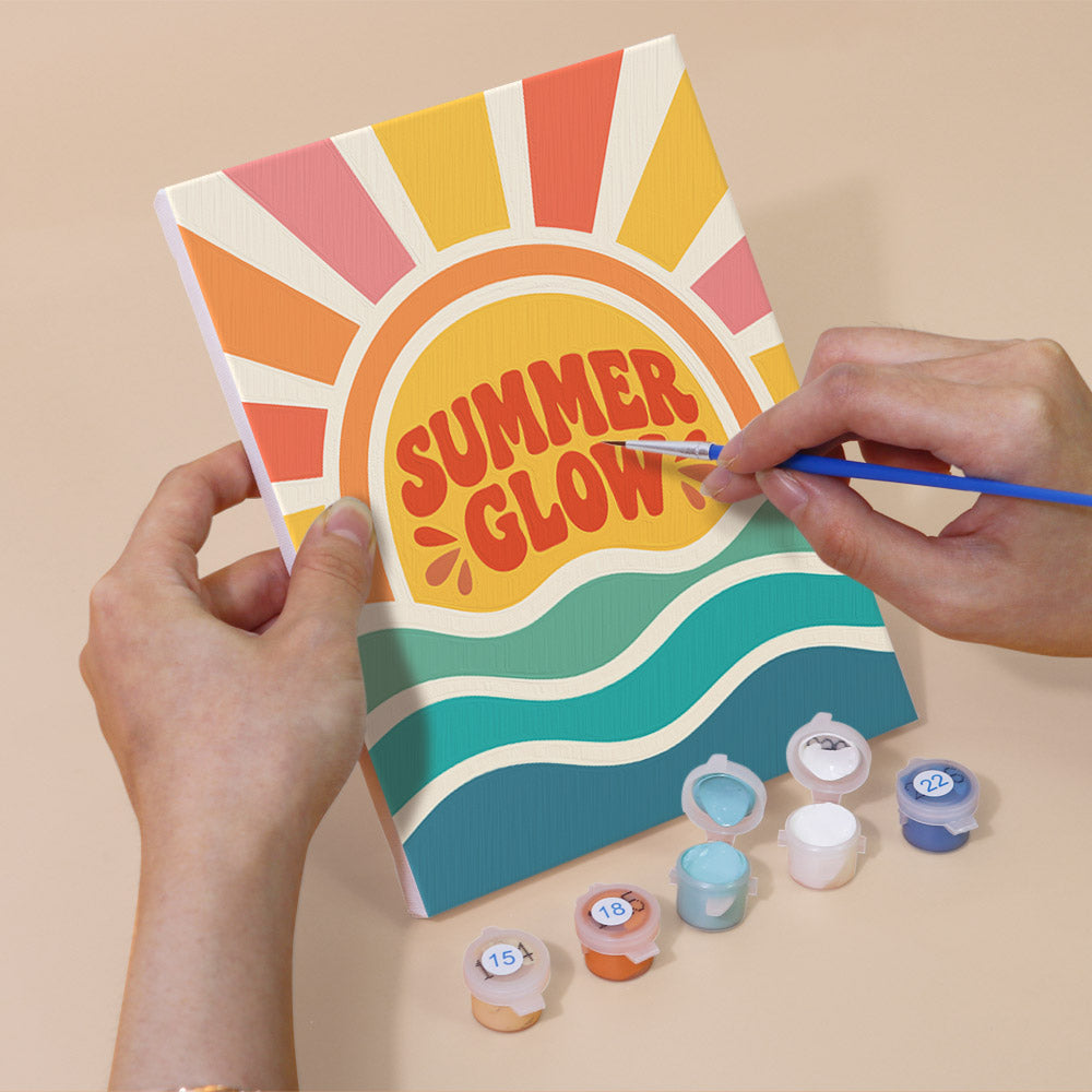 Hand holding a Summer Glow mini canvas while painting the details