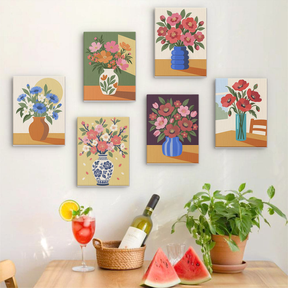 Six finished Sunlit Bouquets mini paintings hung on a wall above a table