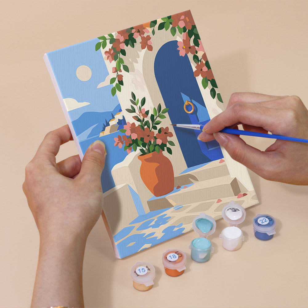 Hand holding a Sunny Doorways mini canvas while painting the details
