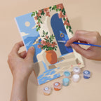 Hand holding a Sunny Doorways mini canvas while painting the details