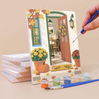 Painting a Sunny Doorways mini canvas propped up beside numbered acrylic paints