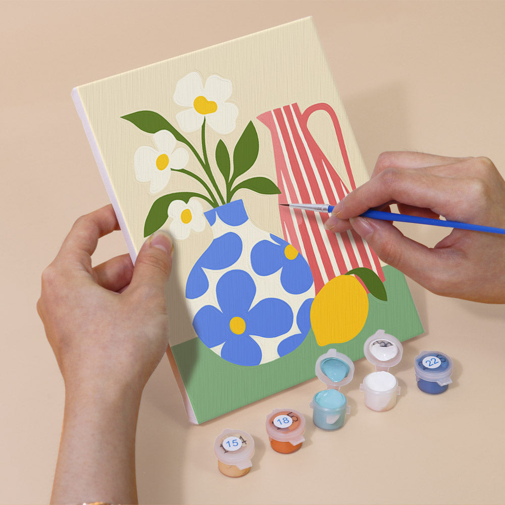 Hand holding a Sunny Kitchen Table mini canvas while painting the details