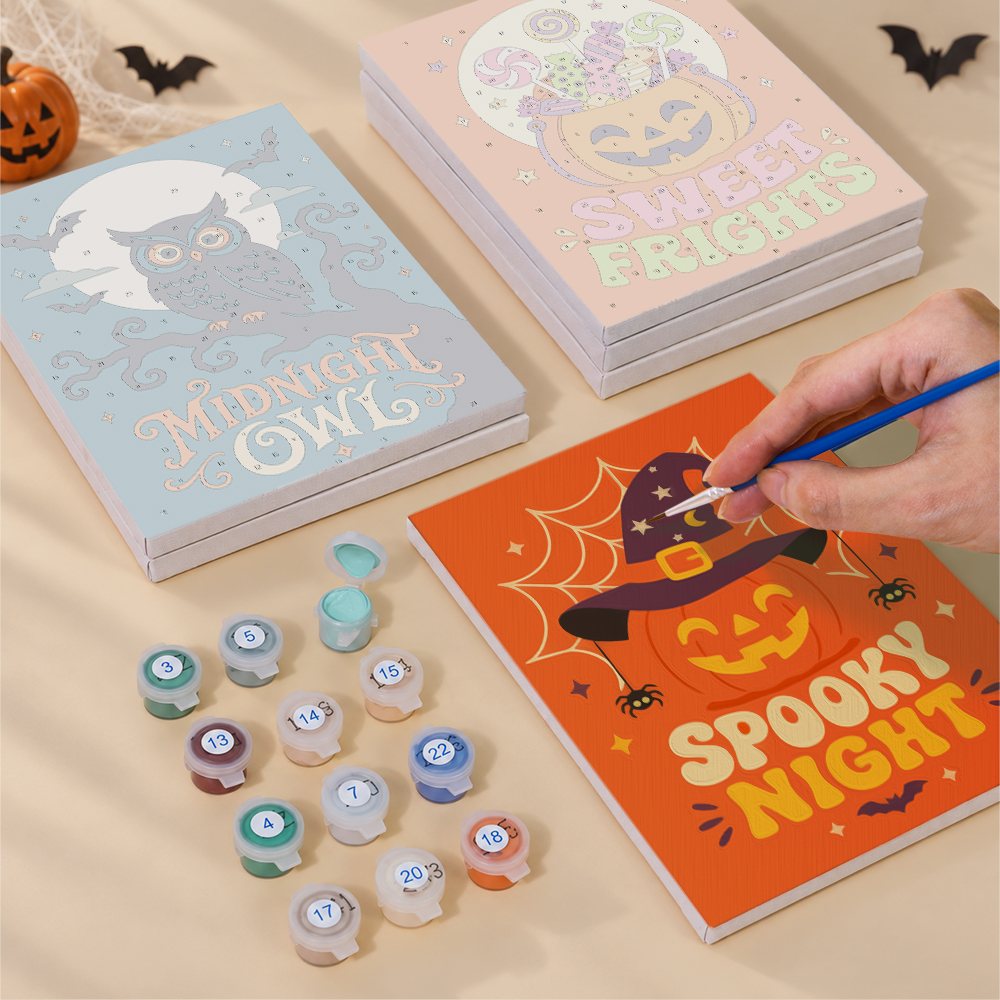 Painting one of the Sweet Frights designs next to a stack of mini canvases