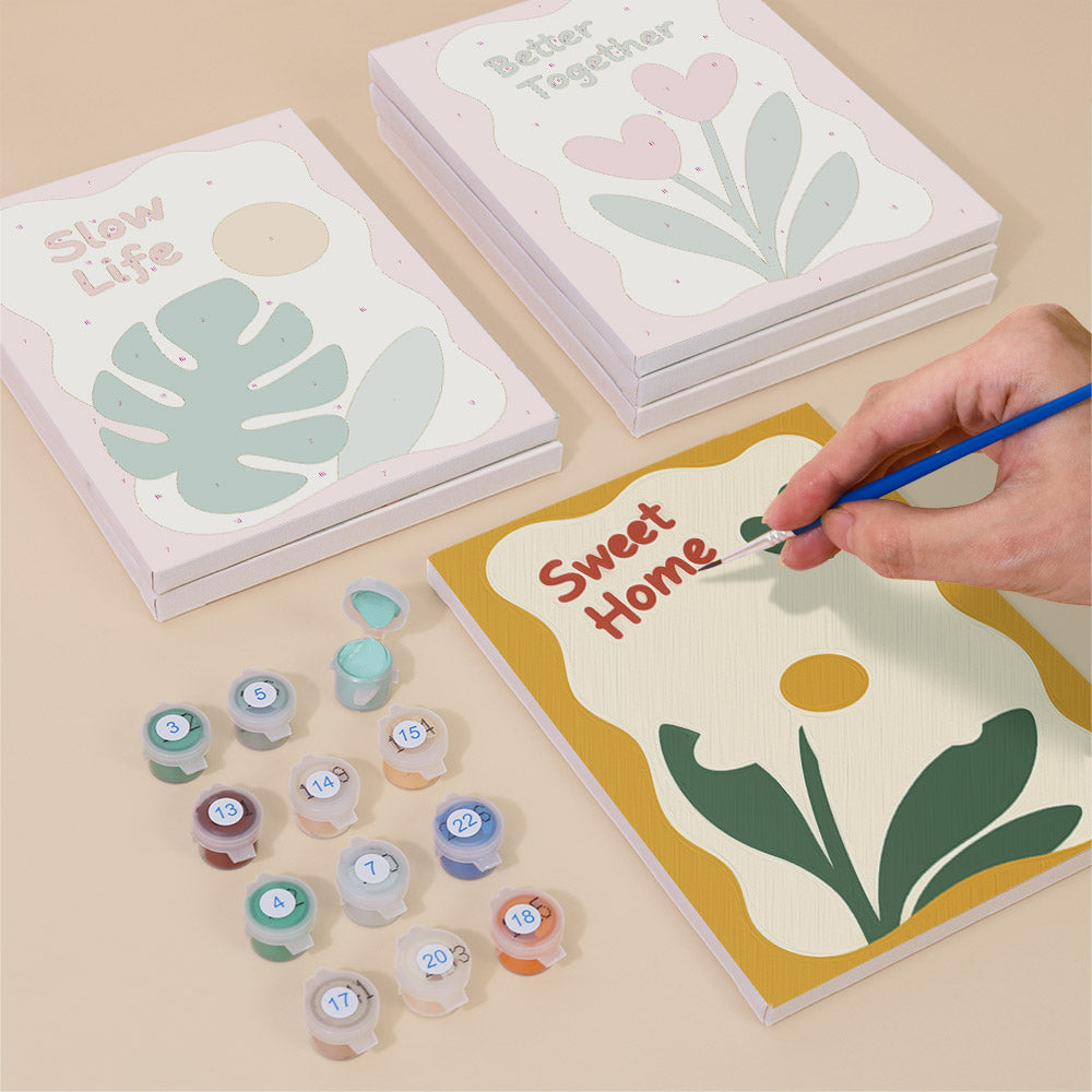Painting one of the Sweet Sayings designs next to a stack of mini canvases