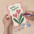 Hand holding a Sweet Sayings mini canvas while painting the details