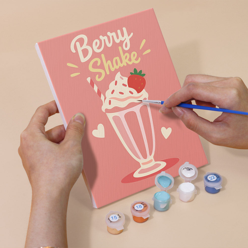 Hand holding a Sweet Shop mini canvas while painting the details
