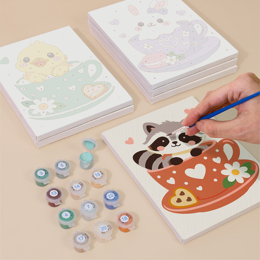 Painting one of the Teacup Critters designs next to a stack of mini canvases