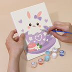 Hand holding a Teacup Critters mini canvas while painting the details
