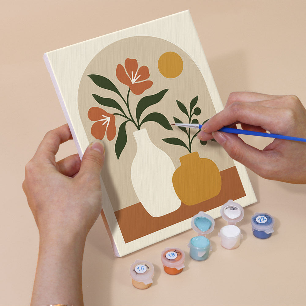 Hand holding a Terracotta Arches mini canvas while painting the details
