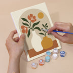 Hand holding a Terracotta Arches mini canvas while painting the details