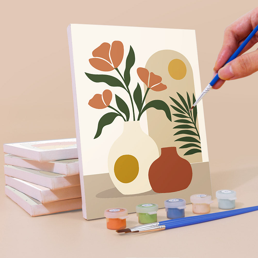 Painting a Terracotta Arches mini canvas propped up beside numbered acrylic paints