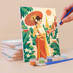 Painting a Thailand Escape mini canvas propped up beside numbered acrylic paints