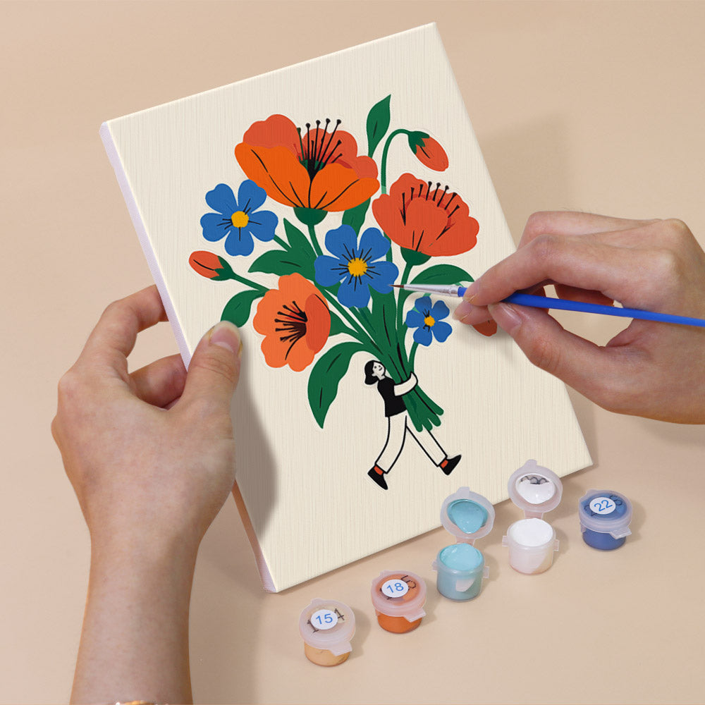 Hand holding a Tiny Gardeners mini canvas while painting the details
