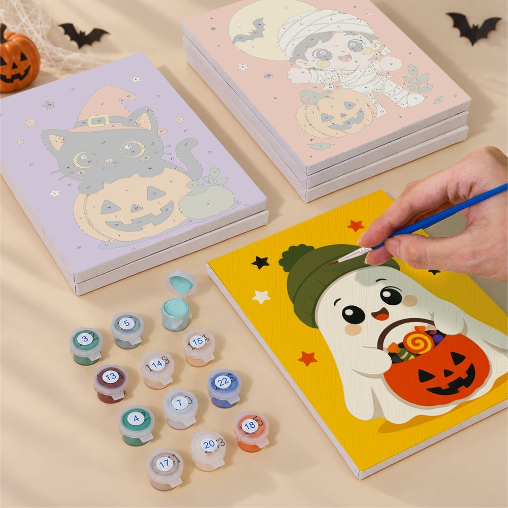 Painting one of the Tiny Trick-or-Treaters designs next to a stack of mini canvases