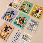 Painting one of the Toadstool Halloween Friends designs next to a stack of mini canvases