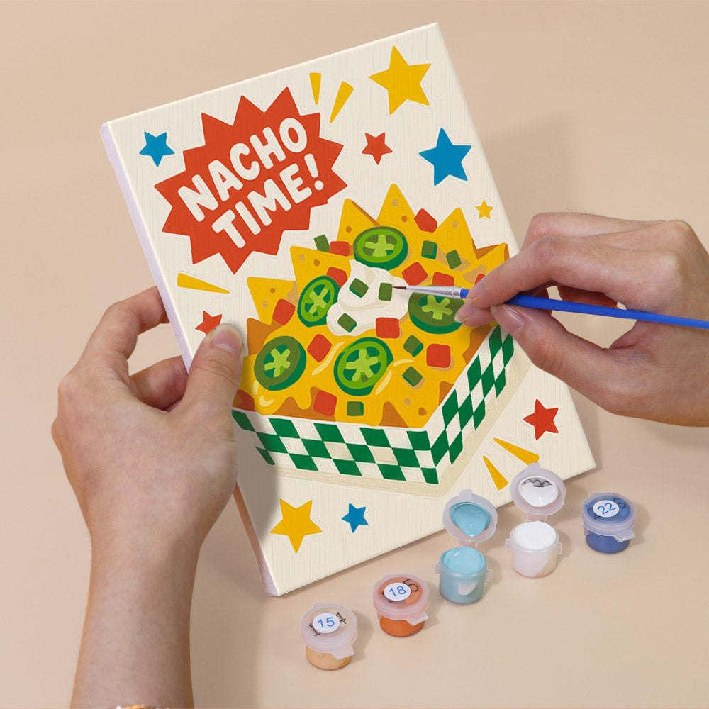 Hand holding a Treat Time mini canvas while painting the details