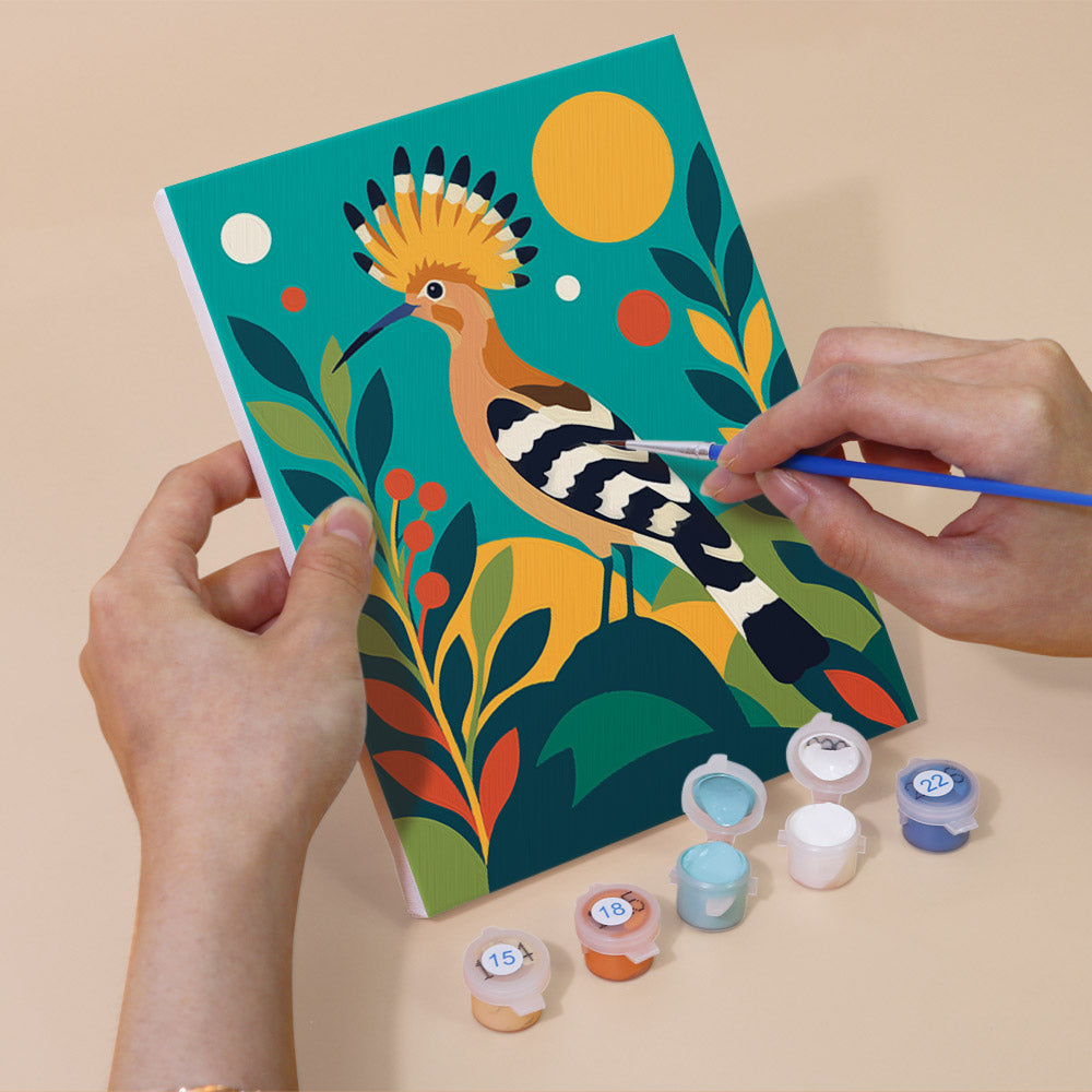 Hand holding a Tropical Birds mini canvas while painting the details