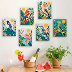 Six finished Tropical Birds mini paintings hung on a wall above a table