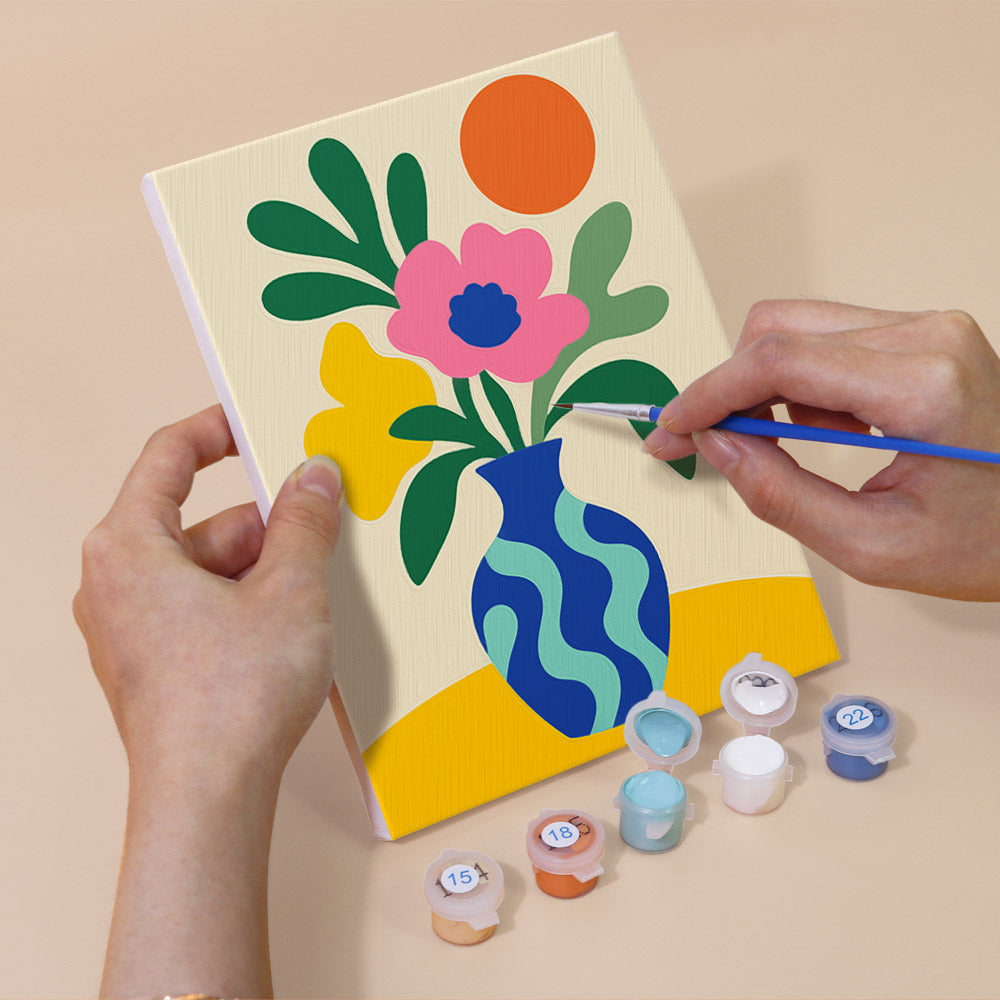 Hand holding a Tropical Cutouts mini canvas while painting the details