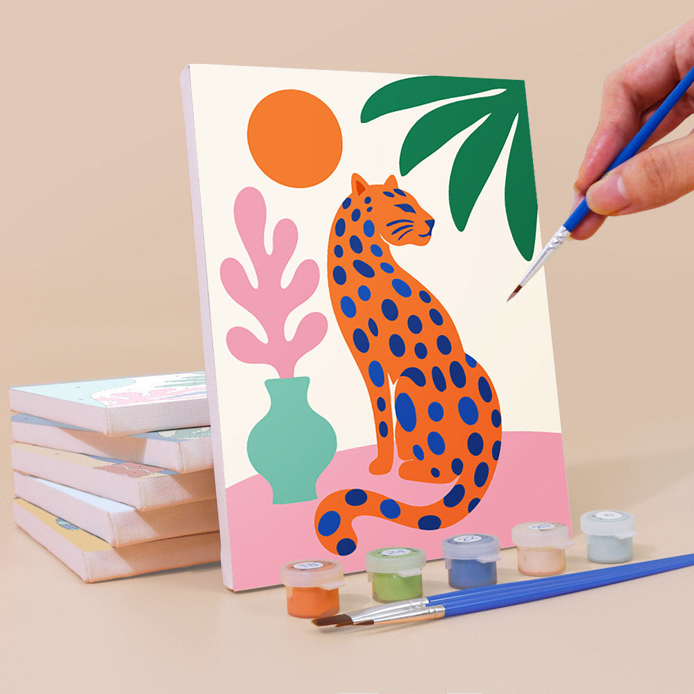 Painting a Tropical Cutouts mini canvas propped up beside numbered acrylic paints