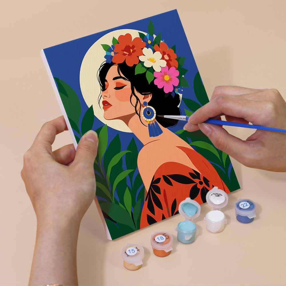 Hand holding a Tropical Muses mini canvas while painting the details