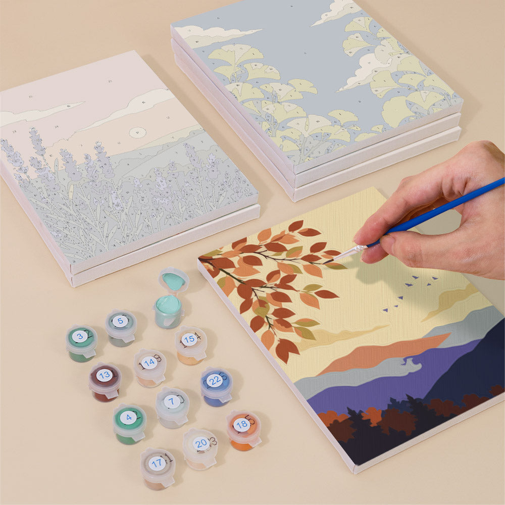 Painting one of the Twilight Meadows designs next to a stack of mini canvases