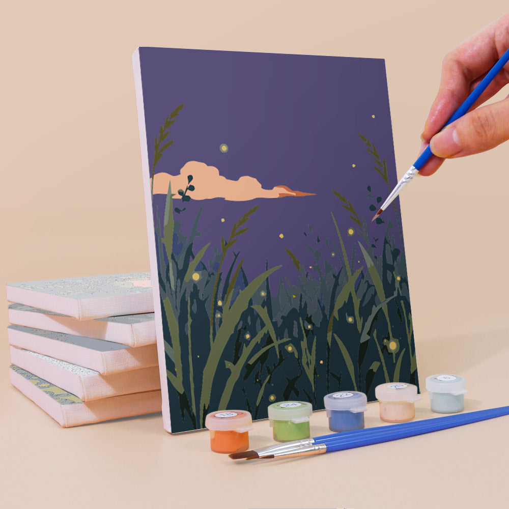 Painting a Twilight Meadows mini canvas propped up beside numbered acrylic paints
