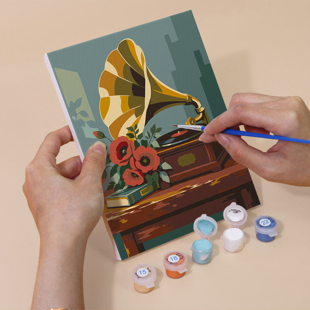 Hand holding a Vintage Keepsakes mini canvas while painting the details