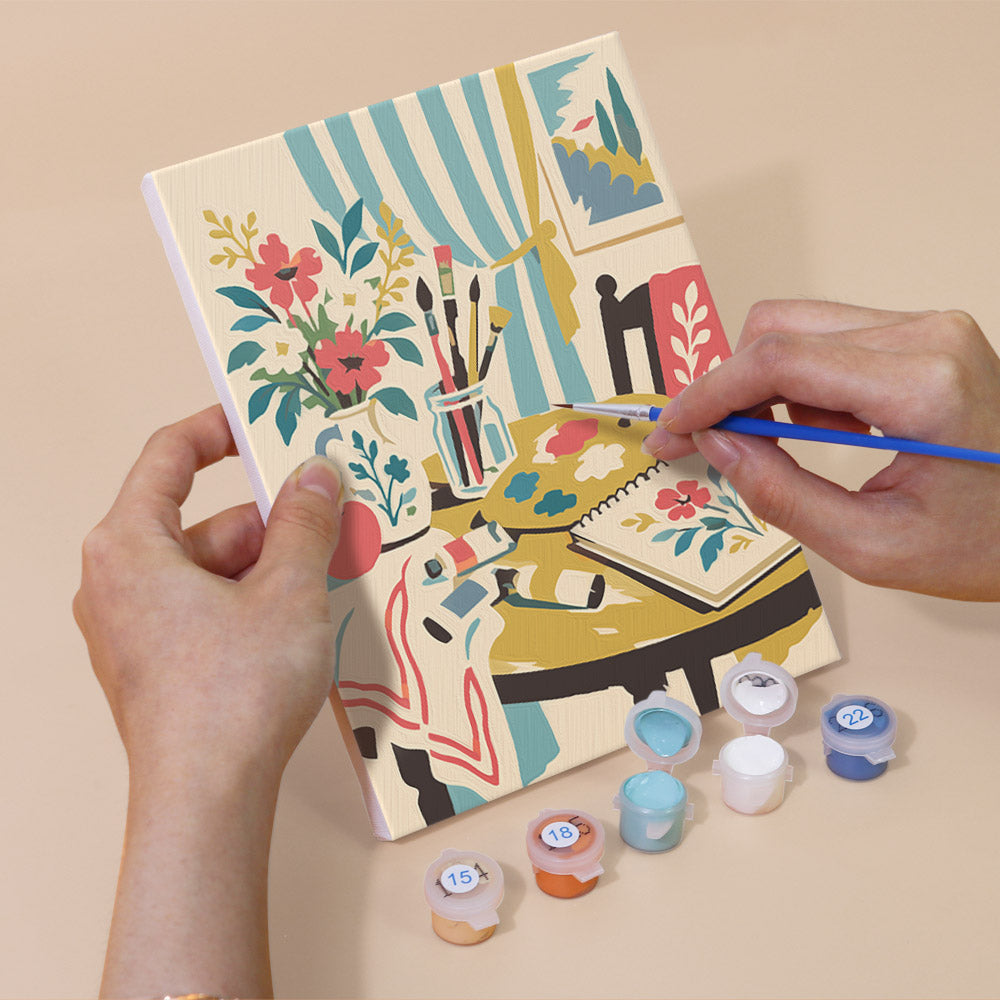 Hand holding a Vintage Romance mini canvas while painting the details