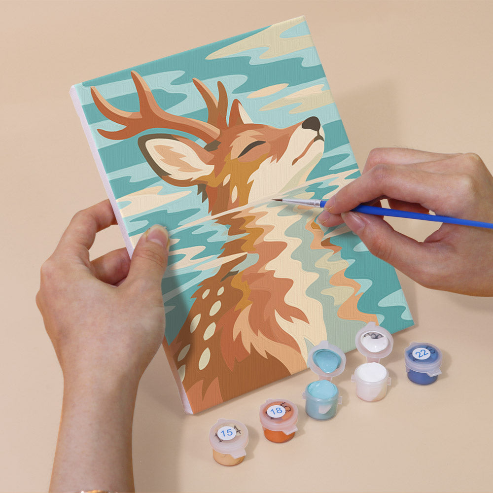 Hand holding a Water Reflections mini canvas while painting the details