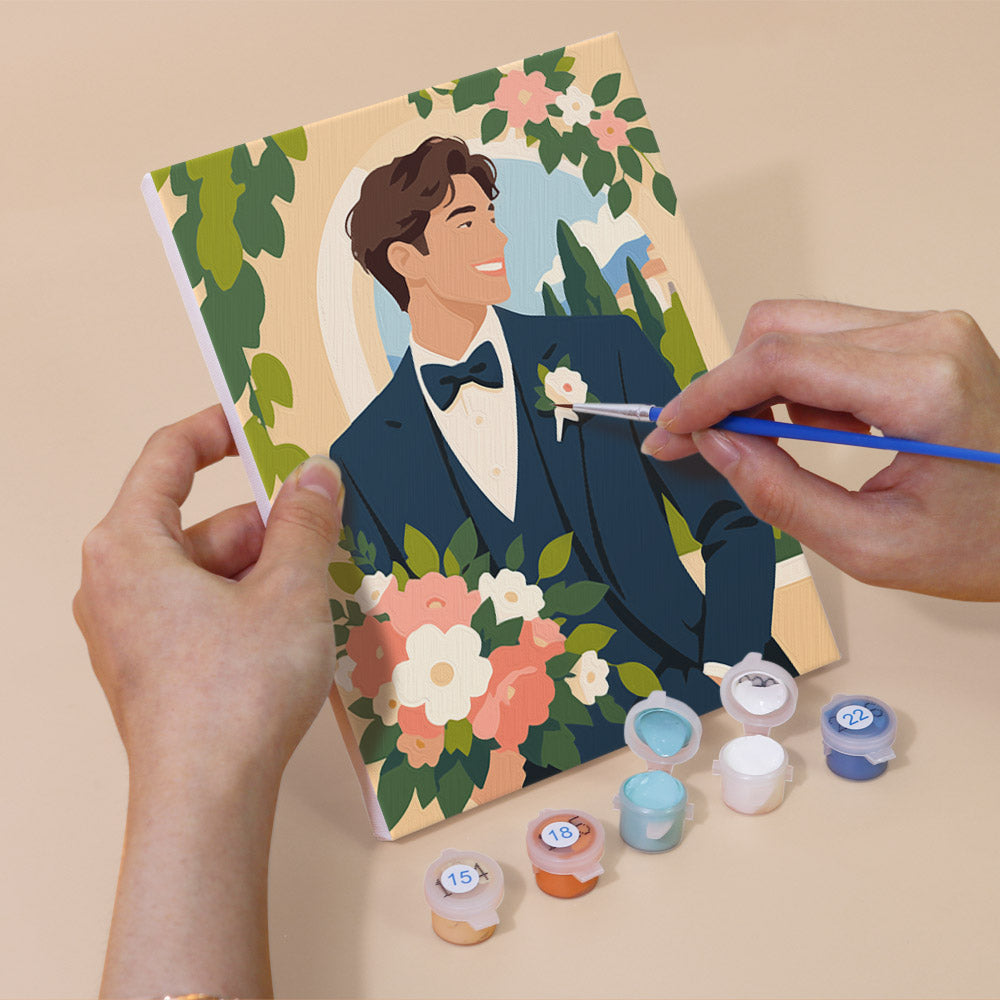 Hand holding a Wedding Day mini canvas while painting the details