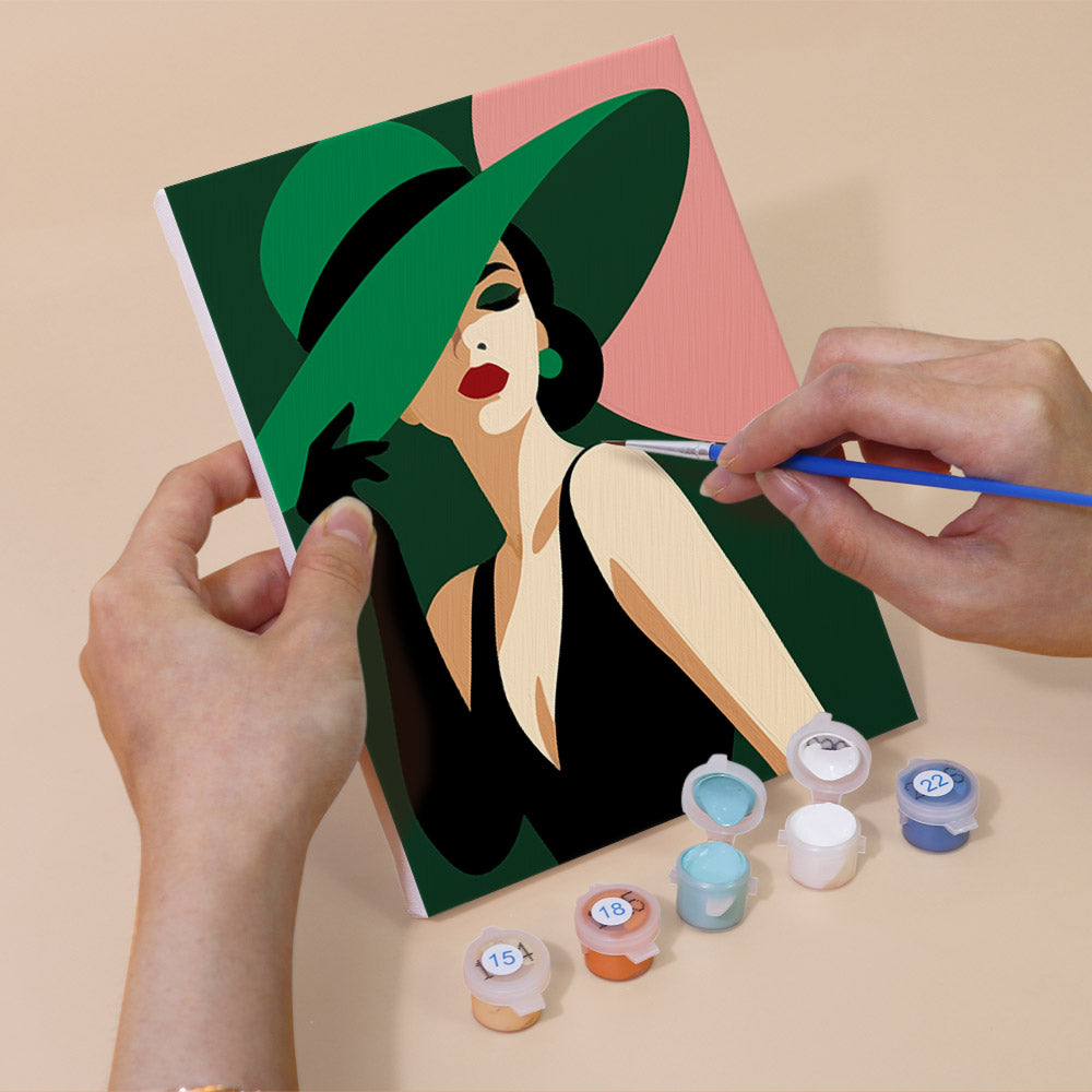 Hand holding a Wide-Brim Glamour mini canvas while painting the details