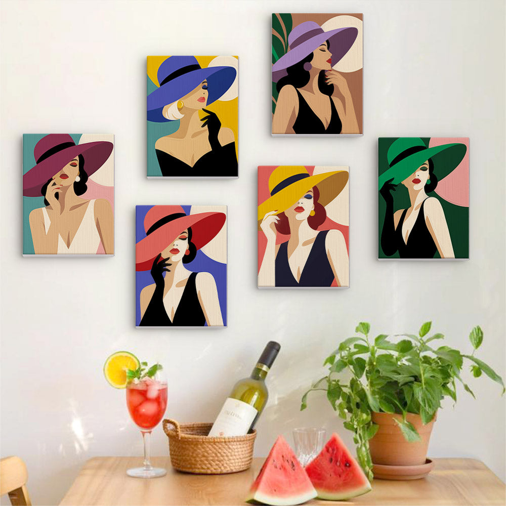 Six finished Wide-Brim Glamour mini paintings hung on a wall above a table