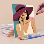 Painting a Wide-Brim Glamour mini canvas propped up beside numbered acrylic paints
