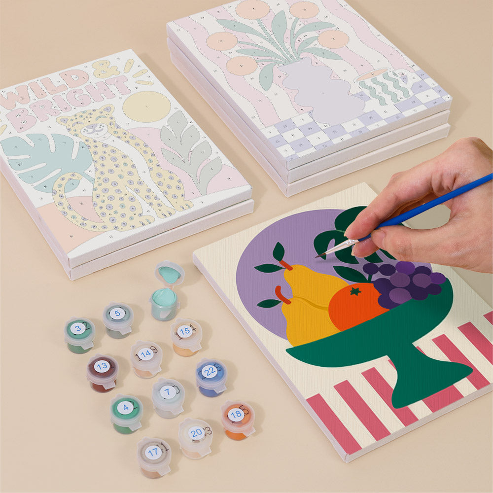 Painting one of the Wild & Bright designs next to a stack of mini canvases