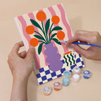 Hand holding a Wild & Bright mini canvas while painting the details