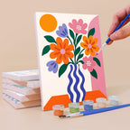 Painting a Wild & Bright mini canvas propped up beside numbered acrylic paints