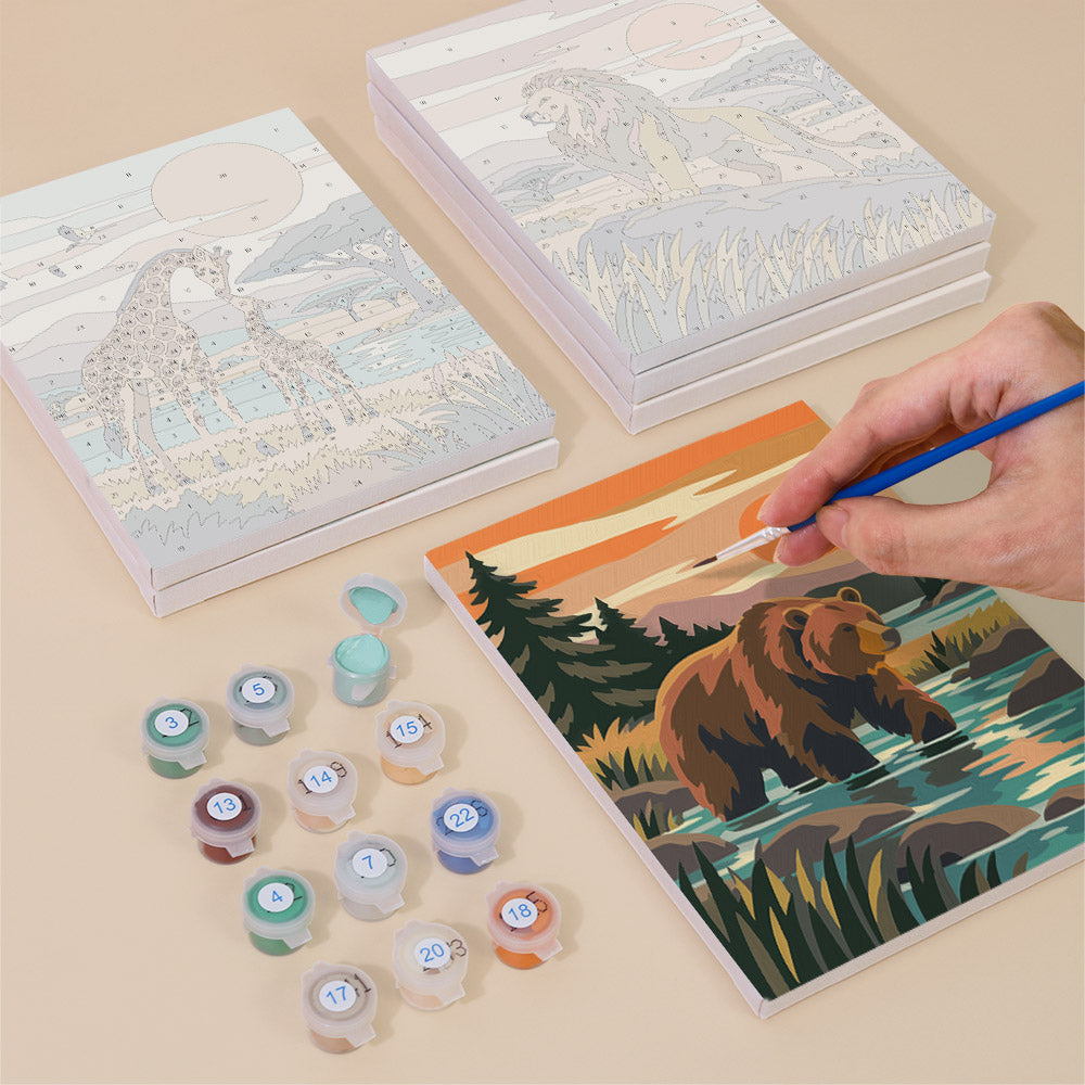 Painting one of the Wild Waterholes designs next to a stack of mini canvases