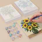 Painting one of the Wildflower Vases designs next to a stack of mini canvases