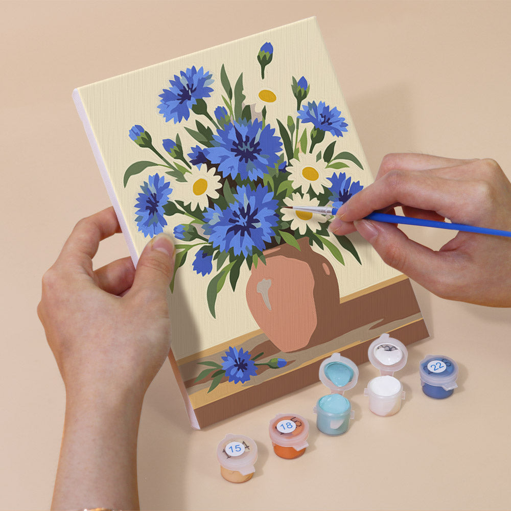 Hand holding a Wildflower Vases mini canvas while painting the details