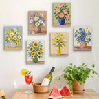 Six finished Wildflower Vases mini paintings hung on a wall above a table