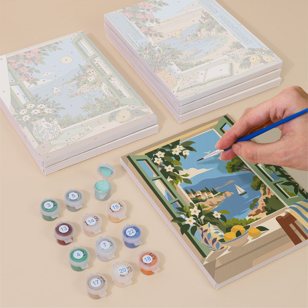 Painting one of the Windows to the Sea designs next to a stack of mini canvases