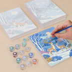 Painting one of the Winter Wonderland designs next to a stack of mini canvases