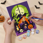 Hand holding a Witching Windows mini canvas while painting the details