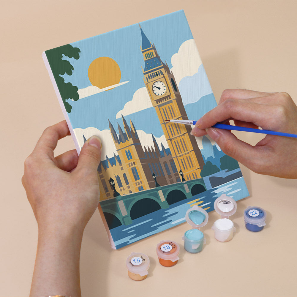 Hand holding a World Landmarks mini canvas while painting the details