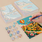 Painting one of the World Wanderer designs next to a stack of mini canvases