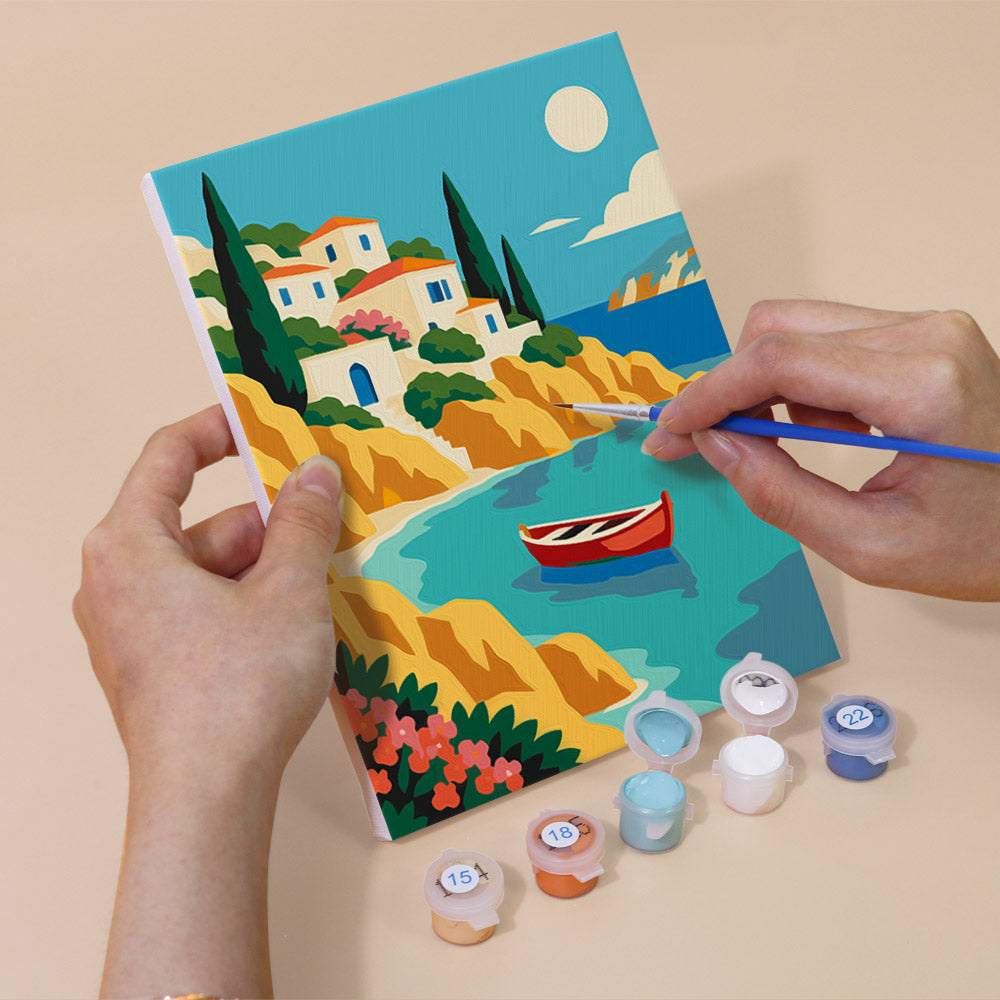 Hand holding a World Wanderer mini canvas while painting the details